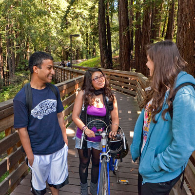 Three students on walking bridge