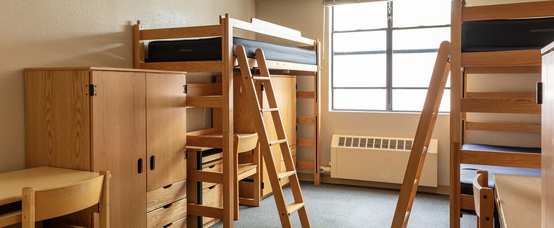 University Town Center triple room with bunk beds, lofted bed, wardrobes, and desks